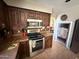 Kitchen features dark cabinetry, stainless steel appliances, and unique saloon doors at 723 W Milada Dr, Phoenix, AZ 85041