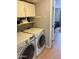Functional laundry room with washer, dryer, upper cabinets and tiled floor at 723 W Milada Dr, Phoenix, AZ 85041