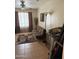 Cozy living room with tile floors, futon, and bright window with decorative curtains and patterned area rug at 723 W Milada Dr, Phoenix, AZ 85041