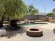 Lush backyard featuring a gorgeous private pool with beautiful rock waterfall feature and fire pit at 723 W Milada Dr, Phoenix, AZ 85041