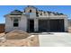 New construction home with attached two car garage with partial roof and exterior frame at 7369 W Buckhorn Trl, Peoria, AZ 85383
