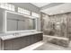 Modern bathroom featuring double vanity, marble shower, and glass block window accents at 7525 E Gainey Ranch Rd # 118, Scottsdale, AZ 85258