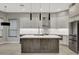 Open kitchen featuring stainless steel appliances, gray cabinetry, and a large center island with bar seating at 7525 E Gainey Ranch Rd # 118, Scottsdale, AZ 85258