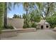 A cozy outdoor kitchen with built-in grill and stucco counter surrounded by lush desert landscaping at 7525 E Gainey Ranch Rd # 118, Scottsdale, AZ 85258