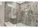 Elegant marble tiled shower with dual shower heads, glass enclosure, and built-in niche at 7525 E Gainey Ranch Rd # 118, Scottsdale, AZ 85258
