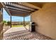 Cozy patio area with a pergola, stone paving, and a convenient outdoor grill at 7618 S Lone Pine Pl, Gold Canyon, AZ 85118