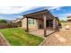 Beautiful backyard featuring lush grass, a stone patio, and a charming pergola at 7618 S Lone Pine Pl, Gold Canyon, AZ 85118