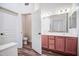 Bathroom featuring double sinks, wood cabinets, and a separate toilet area at 853 E Ivanhoe Ct, Gilbert, AZ 85295