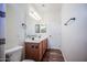 Clean bathroom featuring double sinks, wood-look floor, and modern light fixtures at 853 E Ivanhoe Ct, Gilbert, AZ 85295