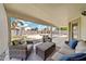 Inviting covered back porch with comfortable seating and a view of the swimming pool in the backyard at 910 S Crossbow Ct, Chandler, AZ 85225