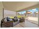 Covered back porch with comfortable seating and a view of the putting green in the backyard at 910 S Crossbow Ct, Chandler, AZ 85225