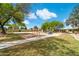 Park playground with swings, play structure, walking path, and picnic area under sunny sky at 910 S Crossbow Ct, Chandler, AZ 85225