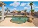 Relaxing backyard pool with rock accents and palm trees under a bright blue sky at 910 S Crossbow Ct, Chandler, AZ 85225