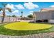 Lush backyard putting green with view of pool and covered patio at 910 S Crossbow Ct, Chandler, AZ 85225