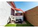 Private backyard featuring a hot tub under a bright red umbrella, surrounded by stylish brick and artificial turf at 9312 E Spiral Ave, Mesa, AZ 85212