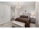 Elegant bedroom featuring a decorative chandelier and an attached bathroom entrance at 9312 E Spiral Ave, Mesa, AZ 85212