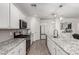 Bright kitchen featuring granite countertops, stainless steel appliances, and stylish white cabinetry at 9312 E Spiral Ave, Mesa, AZ 85212