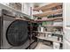 Well-organized laundry room with modern appliances and extensive shelving units at 9312 E Spiral Ave, Mesa, AZ 85212