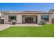Expansive backyard with lush artificial grass, patio, barbecue, and charming playhouse for outdoor enjoyment at 9678 W Patrick Ln, Peoria, AZ 85383