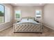 A serene bedroom with a tufted headboard bed, soft carpet, and bright windows for natural light at 9678 W Patrick Ln, Peoria, AZ 85383