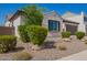 Attractive single-story home with manicured landscaping, rock accents, and lush green bushes at 9678 W Patrick Ln, Peoria, AZ 85383