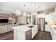 Open-concept kitchen with stainless steel appliances, quartz countertops, and a view of the living room at 9678 W Patrick Ln, Peoria, AZ 85383