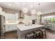 A bright, modern kitchen featuring white cabinets, a large island with seating, and stylish pendant lighting at 9678 W Patrick Ln, Peoria, AZ 85383