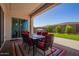 Covered patio with outdoor seating on decorative paving stone overlooks a well-manicured backyard at 9678 W Patrick Ln, Peoria, AZ 85383