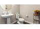 A charming powder room featuring a pedestal sink, toilet, and decorative accents for added appeal at 9678 W Patrick Ln, Peoria, AZ 85383