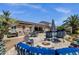 Expansive backyard with covered patio, outdoor kitchen, fire pit, lounge chairs, desert landscaping, and swimming pool at 10359 E Los Lagos Vista Ave, Mesa, AZ 85209