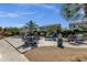 Outdoor dining and lounge area with a fire pit and swimming pool surrounded by lush landscaping at 10359 E Los Lagos Vista Ave, Mesa, AZ 85209