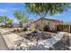 Charming single-story home featuring desert landscaping, mature trees, and a well-maintained front yard with a sidewalk at 10359 E Los Lagos Vista Ave, Mesa, AZ 85209