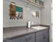 Laundry room featuring gray cabinets, countertop, sink, and convenient storage at 10359 E Los Lagos Vista Ave, Mesa, AZ 85209