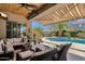 Covered patio with comfortable seating and a view of the sparkling pool and desert landscaping at 10359 E Los Lagos Vista Ave, Mesa, AZ 85209