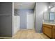 Bright bathroom featuring a bath, tile flooring, neutral paint, and a sink with wooden cabinets at 10548 W Crown King Rd, Tolleson, AZ 85353