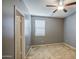 The bedroom features a ceiling fan, a window with blinds, neutral carpet, and gray walls at 10548 W Crown King Rd, Tolleson, AZ 85353