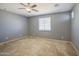 Bedroom featuring neutral paint, carpet flooring, ceiling fan, and bright window at 10548 W Crown King Rd, Tolleson, AZ 85353