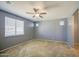 Spacious bedroom with carpeted floors, neutral walls, ceiling fan, and a bright window at 10548 W Crown King Rd, Tolleson, AZ 85353