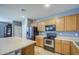 Well-equipped kitchen boasting modern appliances, wooden cabinetry, and a center island for meal prep and seating at 10548 W Crown King Rd, Tolleson, AZ 85353