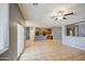 Open-concept living room with kitchen view, tile flooring, and sliding glass doors to the backyard at 10548 W Crown King Rd, Tolleson, AZ 85353