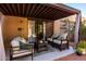Covered patio boasts comfortable seating, a woven coffee table, and a tranquil outdoor living space at 10863 N 117Th Pl, Scottsdale, AZ 85259