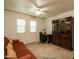 Bright home office with plush sofa, desk, and attractive built-in dark-wood display shelves at 11141 W Cameo Dr, Sun City, AZ 85351