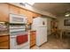 Bright kitchen featuring tile countertops, backsplash and white appliances at 11141 W Cameo Dr, Sun City, AZ 85351
