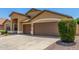 The attached garage has brown doors and is surrounded by desert landscaping at 11303 E Pratt Ave, Mesa, AZ 85212