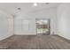 Bright living room featuring neutral carpet, a ceiling fan and sliding doors to the backyard at 11303 E Pratt Ave, Mesa, AZ 85212