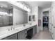 Well-lit bathroom features a long vanity, double mirrors and sinks, plus a glass shower and walk-in closet at 13171 W Redstone Dr, Peoria, AZ 85383
