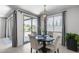 Bright dining area featuring a round table, modern chandelier, and sliding doors to the backyard at 13171 W Redstone Dr, Peoria, AZ 85383