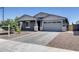 Charming single-Gathering home featuring a gray exterior, a two-car garage, and a well-maintained front yard at 13171 W Redstone Dr, Peoria, AZ 85383
