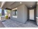 Inviting covered front porch featuring gray brick, neutral colors, and a well-lit entryway at 13171 W Redstone Dr, Peoria, AZ 85383