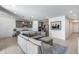 Spacious living room featuring gray couches, an open floor plan, and adjacent kitchen at 13171 W Redstone Dr, Peoria, AZ 85383
